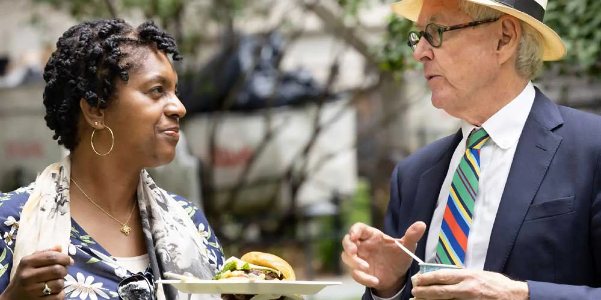 Man and woman chat in Trinity's churchyard during a spring picnic.