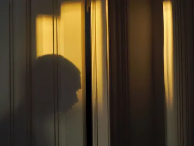 The shadow of a person standing in front of a door.