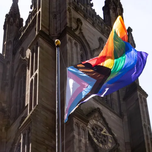 The pride flag with the church in the background